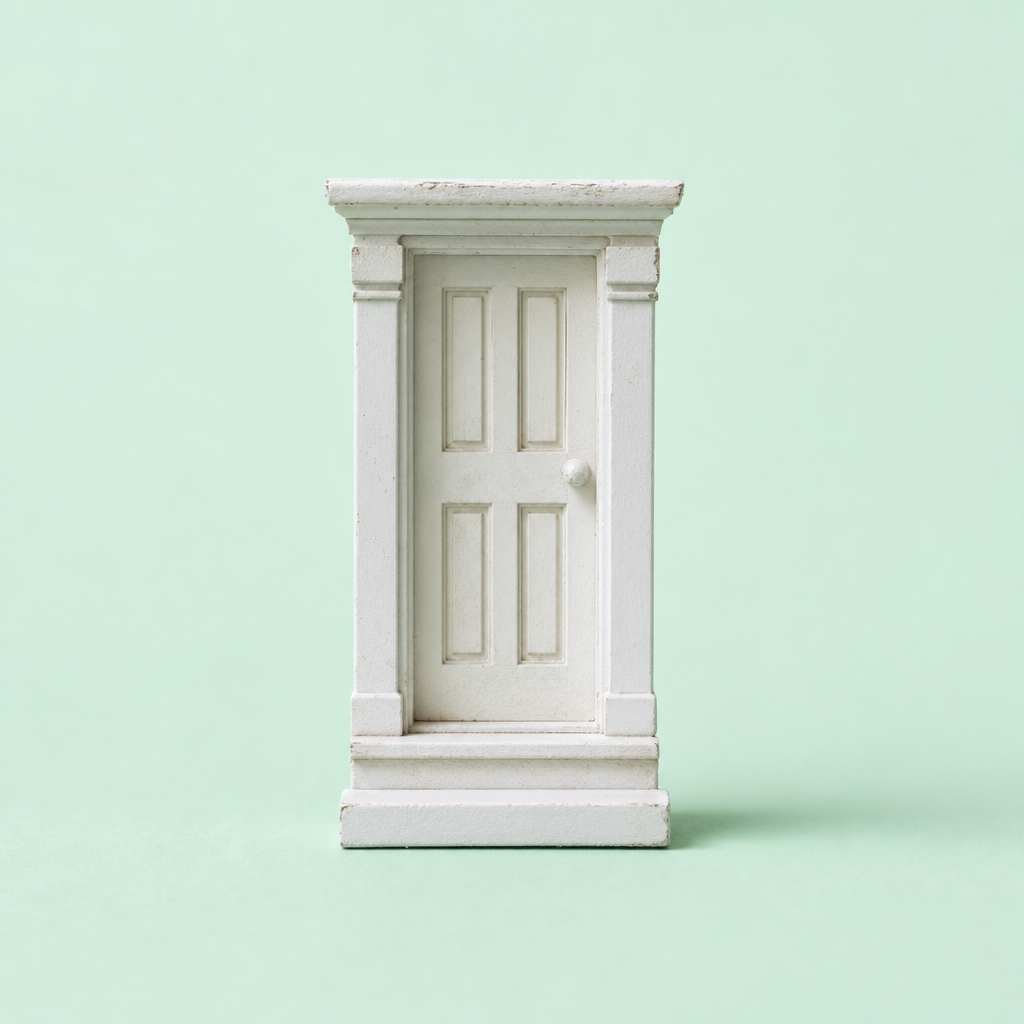 A small white model door with classical columns stands upright against a plain light green background, symbolizing Philippine real estate on June 13, 2026.